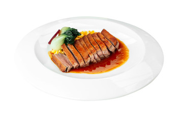 Isolated Roasted Duck Breast with cream of corn and tamarind poultry jus.
