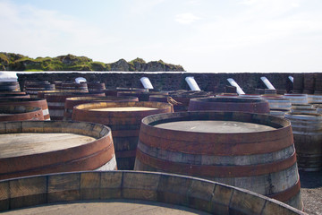 Alte Whiskyfässer in einer Brennerei in denen die Spirituose lagert und reift