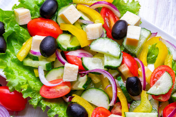 Light summer vegetable salad on a white plate. Close-up, top view