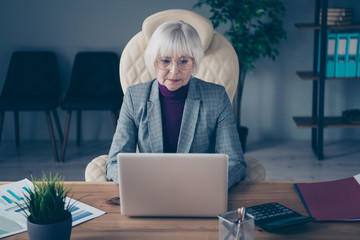 Photo of aged business lady head big organization writing report sitting modern chair notebook table wear specs plaid costume jacket