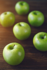 Group of green apples on brown wooden background. Close up