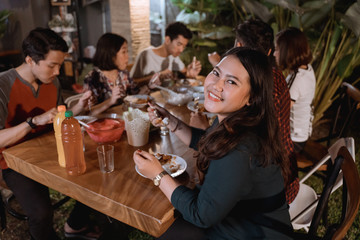 smiling asian woman enjoying their garden dinner party with friend