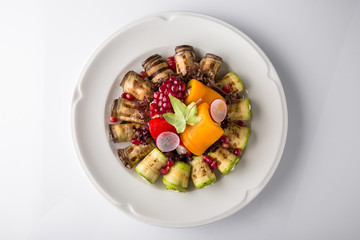 Appetizer of grilled vegetables from zucchini, eggplants, tomatoes, sweet peppers, onions. Rolls stuffed with cheese. Banquet festive dishes. Gourmet restaurant menu. White background.