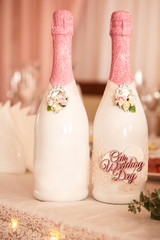 Wedding decoration. Pink bottles of champagne with inscription ''Our wedding day''
