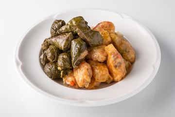 Dolma, rolls of cabbage and grape leaves with rice and meat. Banquet festive dishes. Gourmet restaurant menu. White background.