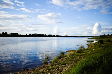 Beautiful landscape with Cumulus clouds. The wide expanse of the river and the lush cloud in the sky on a panoramic image. Oka river, Russia.