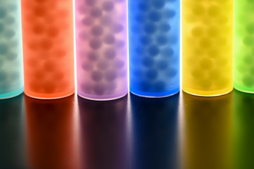 Modern Color homeopathic pills in plastic container on black background