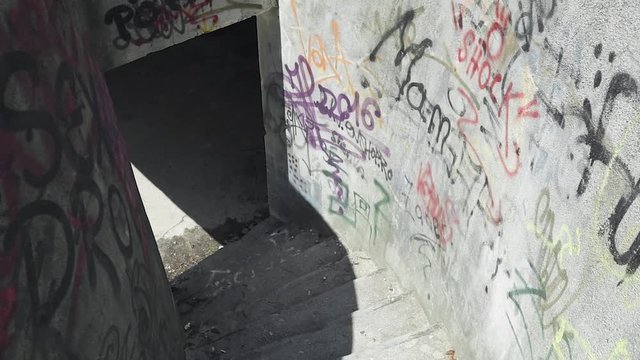 Going dow stairs in an abandoned building. Walls covered in graffiti