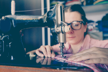 woman seamstress using retro sewing machine