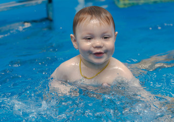 Fototapeta na wymiar little boy swims in the pool