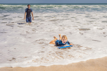 Happy Young boy having fun at the beach on vacation, with Boogie board