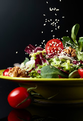 Green salad with cherry tomatoes,  sesame, walnuts and vegetable oil.