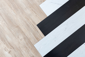 top view of black, white and brown wooden herringbone floor background texture.