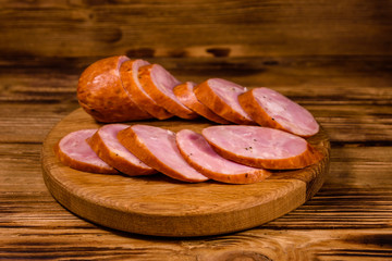 Cutting board with sliced sausage on a wooden table