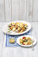 potato, cucumber and red radishes salad with eggs and mustard vinegrette