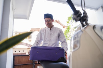 asian muslim male travelling for eid mubarak lebaran by motorcyle. mudik balik kampung concept by...