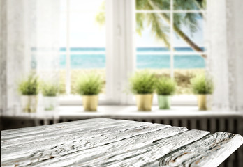 Wooden table background and ocean and beach behind the window