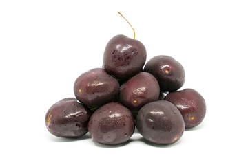 Stack of black cherries isolated on white background.