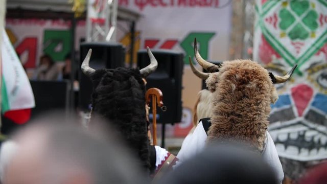 Multiple masked heads with horns dancing together in slow motion