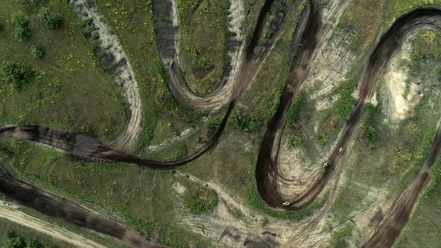 Cross country motorcycling track. Above aerial view on bikers riding fast