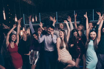 Nice-looking attractive glamorous shine cheerful glad positive stylish ladies and gentlemen having fun festal festive celebratory rising hands up in modern fashionable luxury place indoors