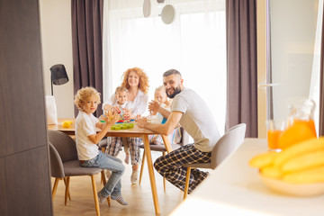 Happy delighted nice family looking at you