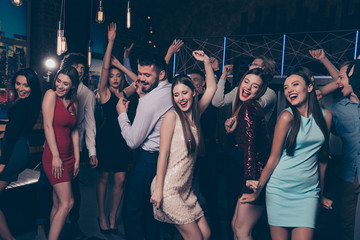 Nice-looking attractive glamorous cheerful positive elegant stylish ladies and gentlemen having fun enjoying festive festal in modern fashionable luxury cool nightclub indoors