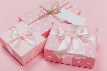 Gift box wrapped in pastel  paper with pink ribbon on pink surface. Top view  and  with copy space.