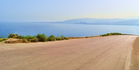 landscape of the coastal road heading to tripoli, lebanon, with mediterranean sea and Tripoli in a far end
