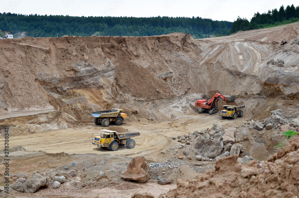 Wall mural excavator developing the sand on the opencast and loading it to the heavy dump truck. processing of 