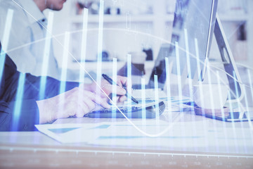 Forex graph with businessman working on computer in office on background. Concept of hardworking. Closeup. Multi exposure.