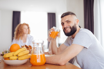 Positive happy man holding a glass with juice