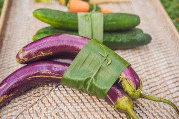 Eco-friendly product packaging concept. Vegetables wrapped in a banana leaf, as an alternative to a plastic bag. Zero waste concept. Alternative packaging