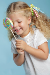 A little girl is holding candy in her hands. 