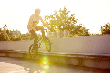Bmx feeble grind one footer on a stone bench at sunset
