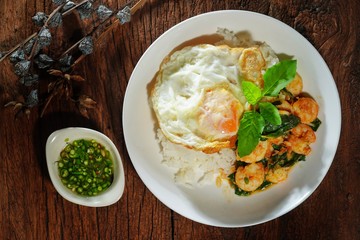 Thai food : Kaphrao Kung is Stirred and fried shrimps with holy basil and chilies served on steamed rice and fried egg. Shooting in studio for advertising. Thai and Asian food concept.