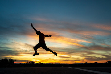 Fototapeta na wymiar Happy man jumping At the time of the sun set Concept of vacation and travel