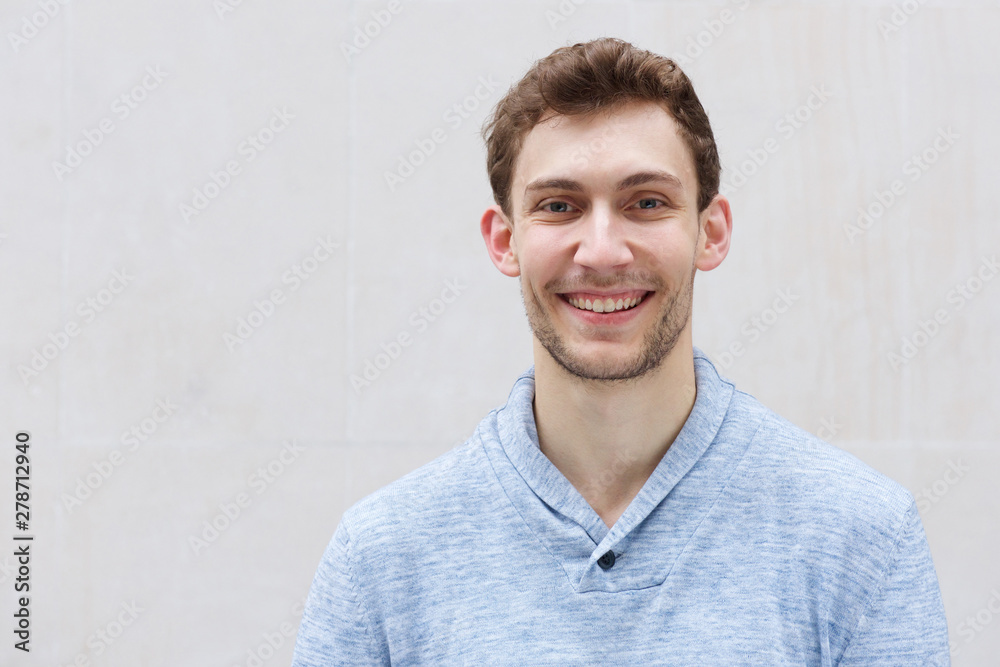 Wall mural front portrait of handsome young man smiling and looking at camera