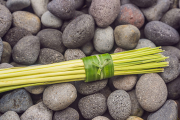 Obraz na płótnie Canvas Eco-friendly product packaging concept. Lemongrass wrapped in a banana leaf, as an alternative to a plastic bag. Zero waste concept. Alternative packaging