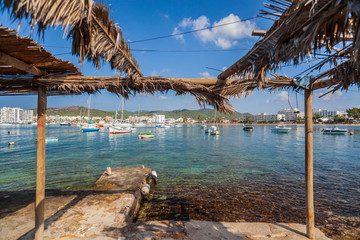 Old stone pier and fisherman house in bay and beach of Sant Antoni de Portmany, Ibiza Island, Balearic islands. Spain.