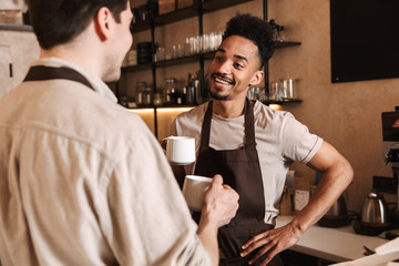 Happy coffee men colleagues in cafe bar working indoors.