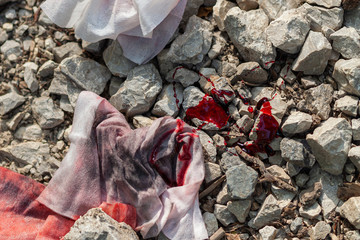 Dirty, old, bloody rags thrown away on the abandoned gravel road 
