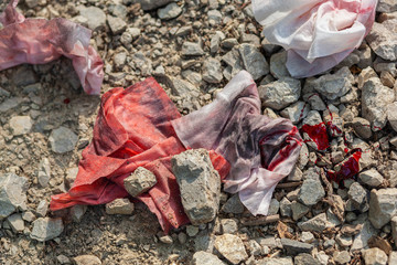Dirty, old, bloody rags thrown away on the abandoned gravel road 