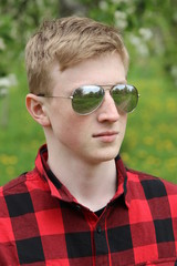 Boy in the red shirt at the city park, summer day, natural lighting.