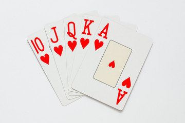A royal straight flush playing cards poker hand in hearts.