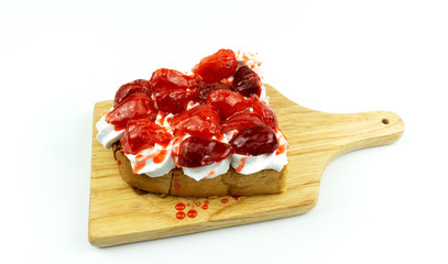 Toast Fruit Strawberry on topped whip cream in a wood plate isolated on white background, Food concept Front view.