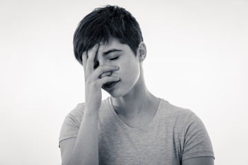 Human expressions and emotions. Young attractive woman sad and depressed. Head resting on her hand.