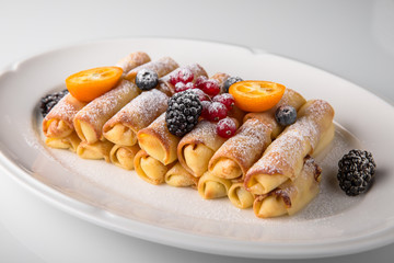 Dessert. Sweet pancakes with jam, caramel, fruit and berries. Banquet festive dishes. Fine dining restaurant menu. White background. 