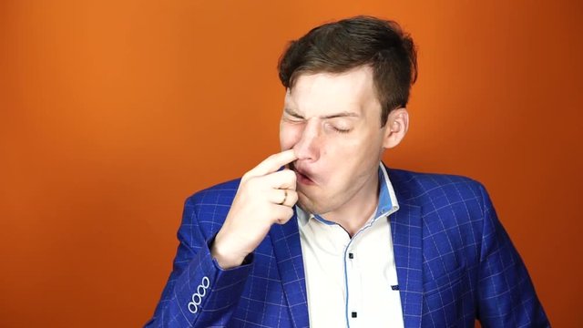 Young european man is picking his nose. Man with finger in his nose, picking the nostrils