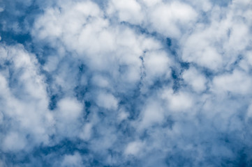 Beautiful snow-white altocumulus clouds against a blue sky. Natural background.